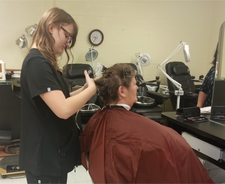 student cutting hair