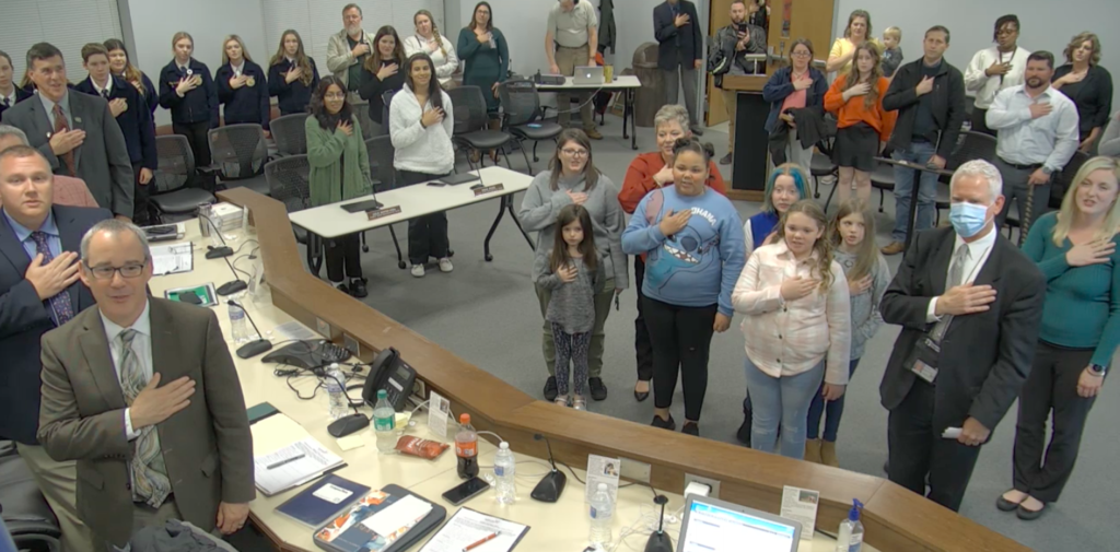 children and adults saying pledge